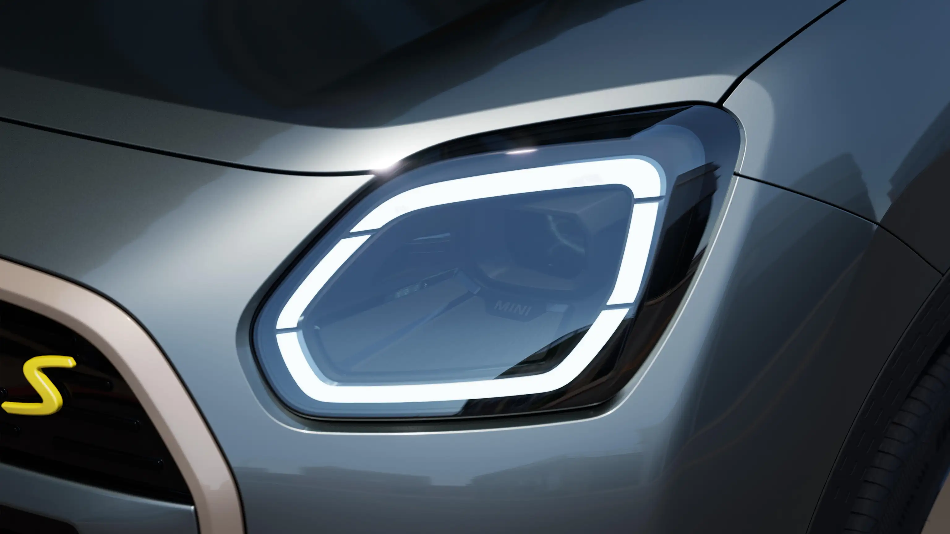 Detail view of the all-electric MINI Countryman headlight with white light on